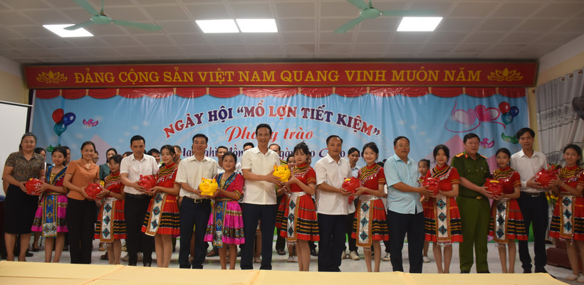 Các đồng chí lãnh đạo huyện Nậm Pồ và học sinh trong huyện hưởng ứng phong trào nuôi lợn đất ủng hộ cho giáo dục. 