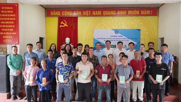 Phó Tổng Giám đốc Đào Việt Ánh cùng đại diện chính quyền địa phương, các nhà tài trợ tặng sổ bảo hiểm xã hội, thẻ bảo hiểm y tế cho người có hoàn cảnh khó khăn bị ảnh hưởng bởi bão số 3 ở Tuyên Quang. (Ảnh: VSS)