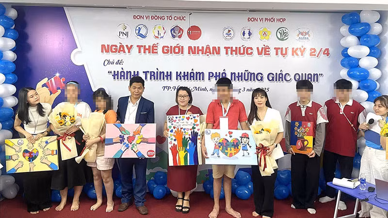 Các bạn nhỏ tặng những bức tranh tự vẽ cho lãnh đạo Quỹ Bảo trợ trẻ em Việt Nam và Công ty CP Vàng bạc đá quý Phú Nhuận PNJ. (Ảnh: NFVC)