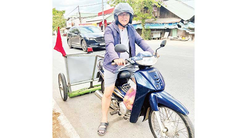 Anh Trần Khắc Vũ cùng xe tự chế hút đinh, vật sắc nhọn giúp bảo đảm an toàn giao thông.