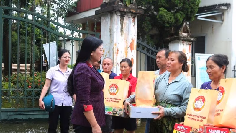 Chủ tịch Ủy ban Mặt trận Tổ quốc Việt Nam thành phố Hà Nội Nguyễn Lan Hương tặng quà và động viên người dân vùng lũ.