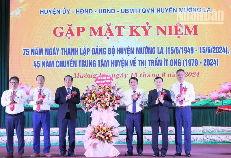 Đồng chí Lò Minh Hùng, Phó Bí thư Thường trực Tỉnh ủy Sơn La tặng hoa chúc mừng 75 năm ngày thành lập Đảng bộ huyện Mường La.