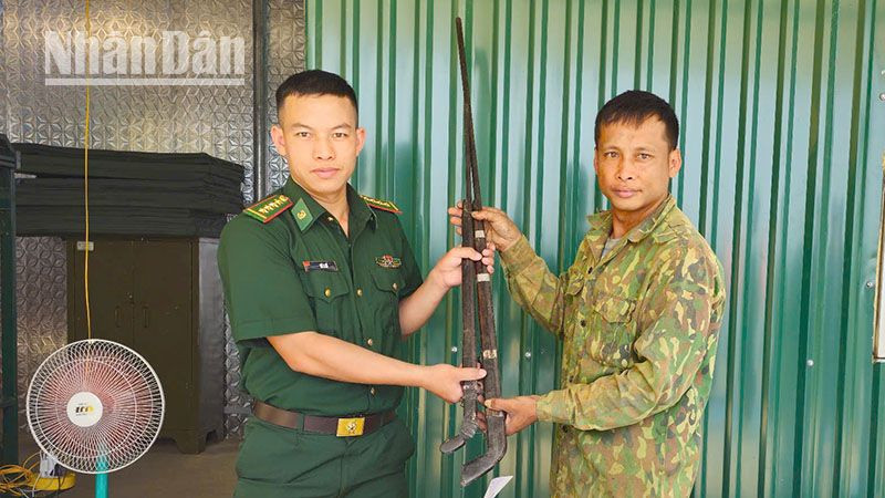 Cán bộ Đồn Biên phòng Mường Cai tiếp nhận 2 khẩu súng tự chế.