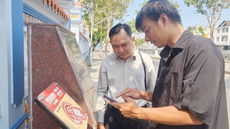 Kỹ sư lắp đặt thiết bị công nghệ hướng dẫn người dân trải nghiệm tại Di tích lịch sử quốc gia Mộ và Đình Nguyễn Trung Trực.