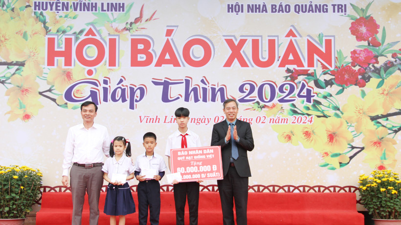 Phó Bí Thư Thường trực Tỉnh ủy, Chủ tịch Hội đồng nhân dân tỉnh Quảng Trị Nguyễn Đăng Quang cùng đại diện Báo Nhân Dân trao 3 suất quà cho học sinh ở xã Vĩnh Sơn, huyện Vĩnh Linh.