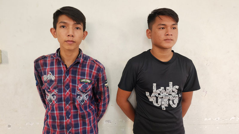 Công an đọc quyết định bắt tạm giam Nguyễn Minh Tâm (bên trái) và Trần Thanh Trọng. 