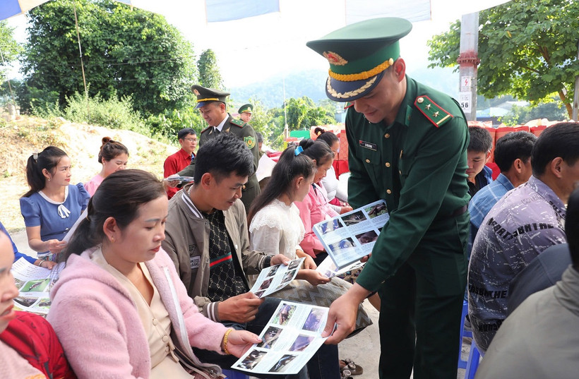Cán bộ, chiến sĩ Bộ đội Biên phòng tỉnh Điện Biên phát tờ rơi tuyên truyền bảo vệ rừng đến nhân dân trên khu vực biên giới Việt-Lào.