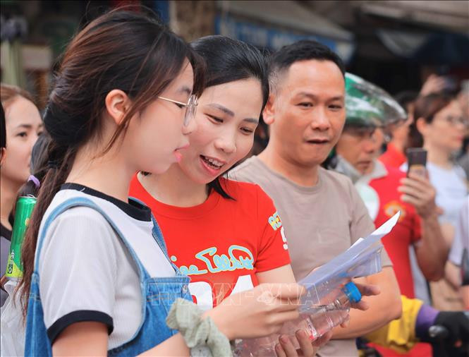 Thí sinh, phụ huynh xem đề thi sau buổi thi Ngữ văn, kỳ thi tuyển sinh vào lớp 10 tại Hà Nội (Ảnh: HOÀNG HIẾU/TTXVN)