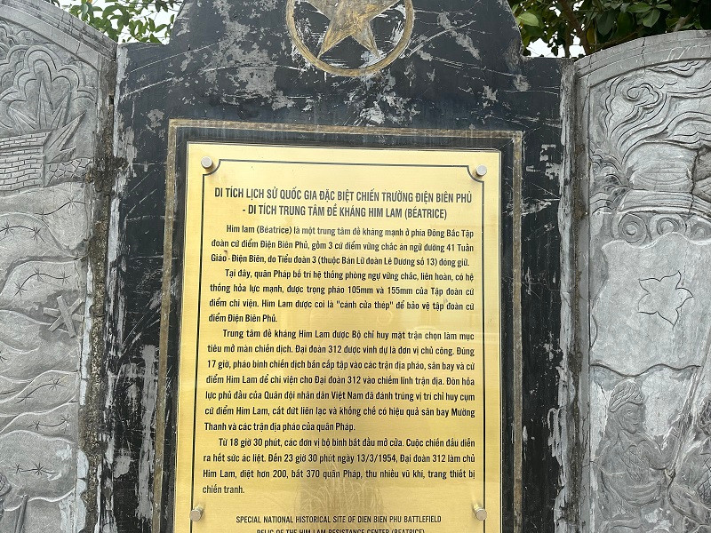 Tấm bia lớn tại Di tích Trung tâm đề kháng Him Lam với nhiều gam màu loang lổ.