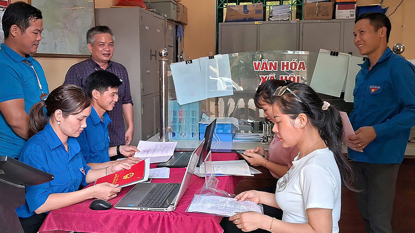 Đội tình nguyện Đoàn Thanh niên xã Phong Dụ Thượng (huyện Văn Yên, tỉnh Yên Bái) cùng cán bộ xã hướng dẫn người dân thực hiện thủ tục hành chính. (Ảnh THANH TÂN)