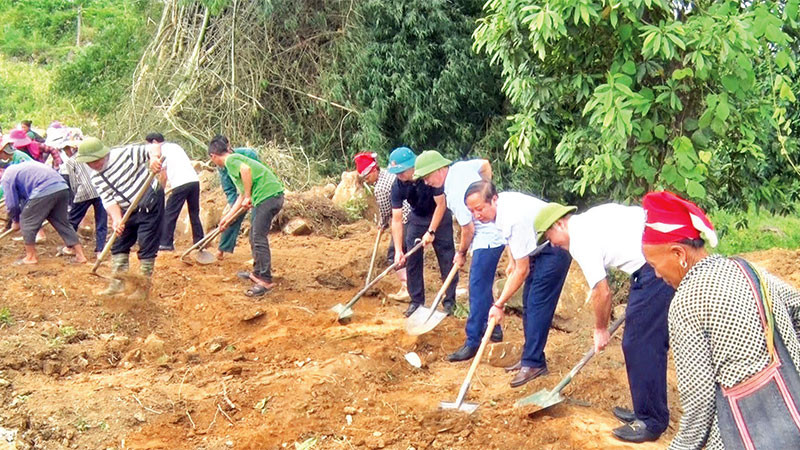 Cán bộ tham gia mở rộng đường nông thôn với người dân địa phương.
