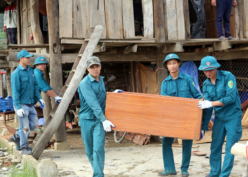 Dân quân và nhân dân xã Thanh Hưng, huyện Điện Biên hỗ trợ người dân di chuyển tài sản khỏi vùng nguy hiểm. (Ảnh: Trần Nhâm)