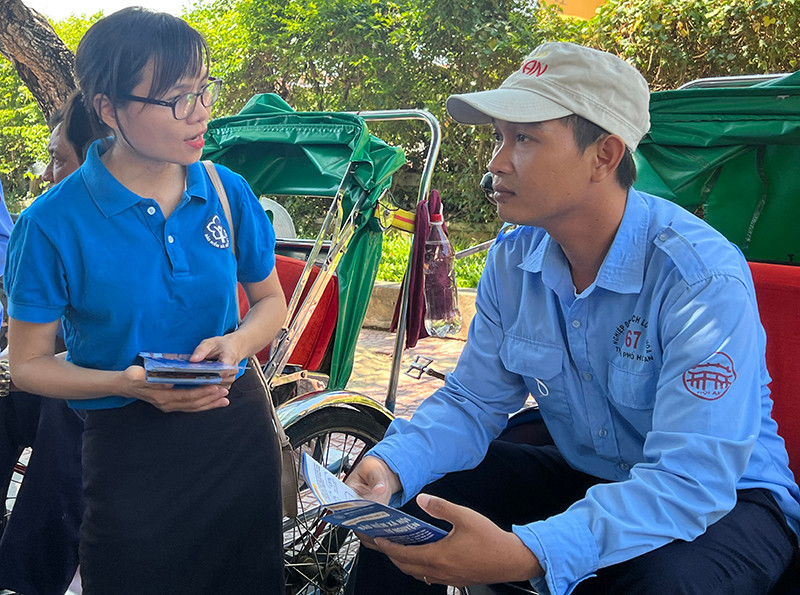 Cán bộ Bảo hiểm xã hội thành phố Hội An tuyên truyền chính sách cho các đoàn viên Nghiệp đoàn xích lô Hội An.