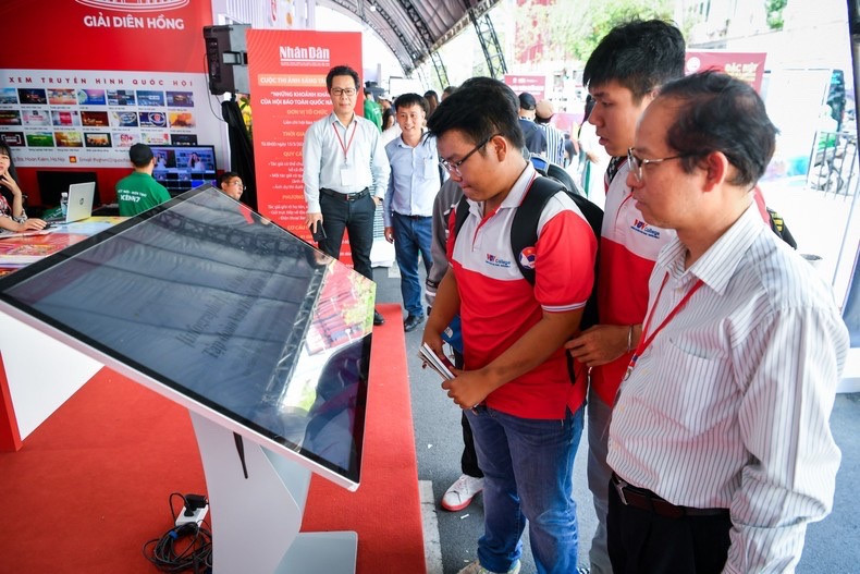 Bạn đọc tham quan, giao lưu tại gian trưng bày của Báo Nhân Dân trong Hội Báo toàn quốc 2024. Ảnh: THÀNH ĐẠT