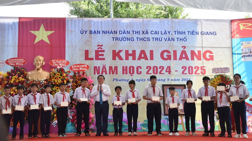 Trưởng Ban Tuyên giáo Trung ương Nguyễn Trọng Nghĩa tặng học bổng cho các em học sinh nghèo nhân dịp lễ khai giảng. 
