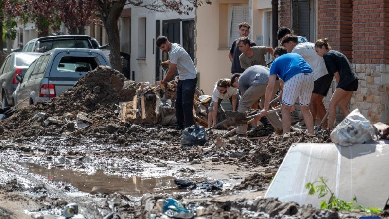 Người dân dọn bùn trên đường phố ở Bahia Blanca, Argentina, ngày 10/3/2025. (Ảnh: XINHUA)