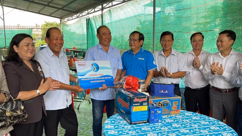 Nguyên Phó Thủ tướng Thường trực Chính phủ Trương Hòa Bình cùng lãnh đạo địa phương tặng quà cho ngư dân.