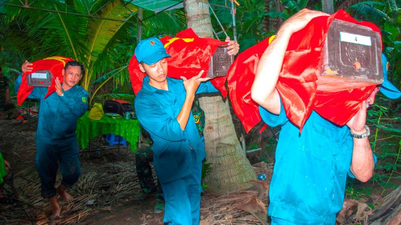 Lực lượng chức năng khai quật và cất bốc hài cốt liệt sĩ.