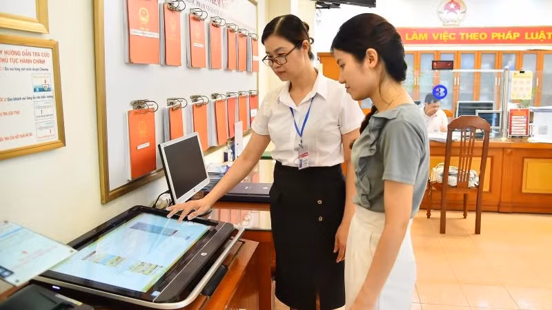 Cán bộ Ủy ban nhân dân phường Thanh Xuân Nam (quận Thanh Xuân, Hà Nội) hướng dẫn người dân thực hiện thủ tục hành chính trên môi trường mạng. (Ảnh: THỦY NGUYÊN)