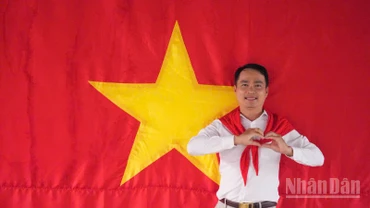 Tiến sĩ Võ Văn Sơn, giảng viên trẻ của Trường đại học Tiền Giang chụp ảnh cùng cờ Tổ quốc.