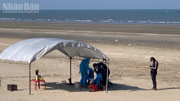 Lực lượng chức năng tiến hành khám nghiệm tử thi tại bờ biển xã Lộc Hà.