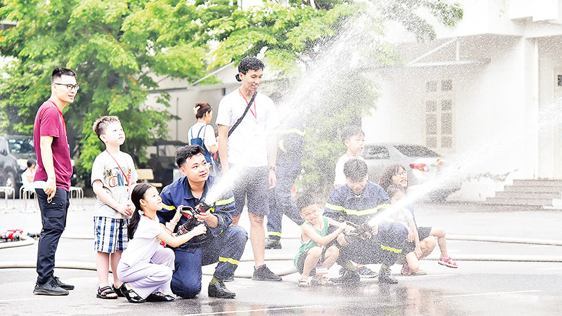 Các em học sinh tham gia thực hành cùng cán bộ, chiến sĩ Trường đại học Phòng cháy chữa cháy. (Ảnh MỸ HÀ) 