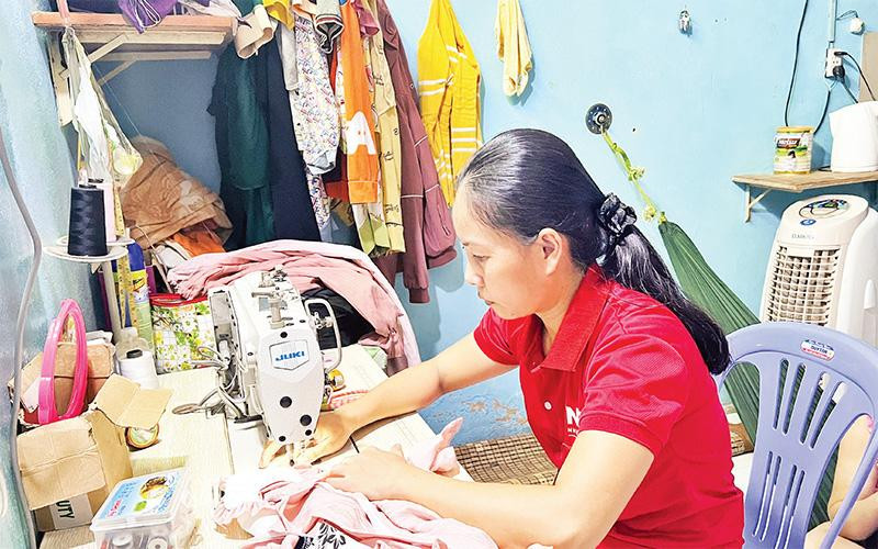 Chị Lê Thị Quyên (công nhân Công ty Nhựa Chợ Lớn) nhận hàng về may gia công tại phòng trọ. 