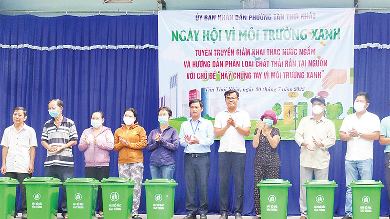 Ðại diện UBND phường Tân Thới Nhất (Quận 12) tặng thùng rác cho người dân. (Ảnh CTV)