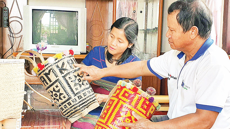 Ông Ha Pall hướng dẫn cách cài nan tạo hoa văn trên gùi cho lớp trẻ. 