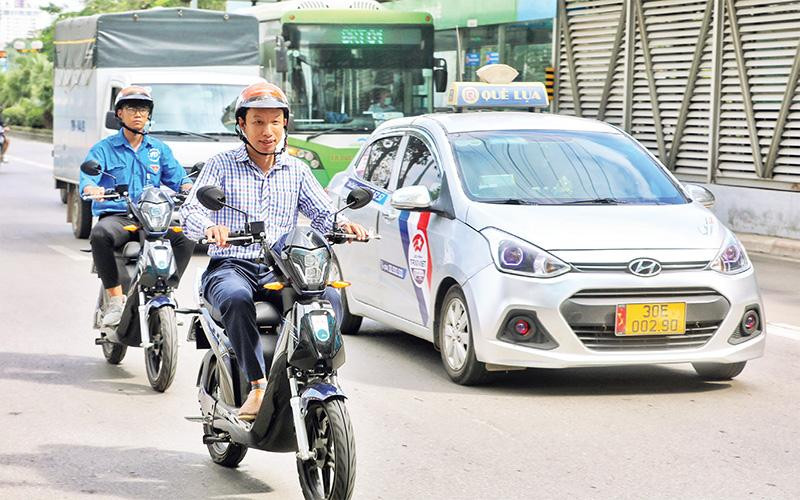 Người dân trải nghiệm sử dụng xe điện 2 bánh trong chương trình "Thí điểm mô hình xe điện 2 bánh kết nối phương tiện vận tải hành khách công cộng tuyến BRT". (Ảnh Lê Khánh) 