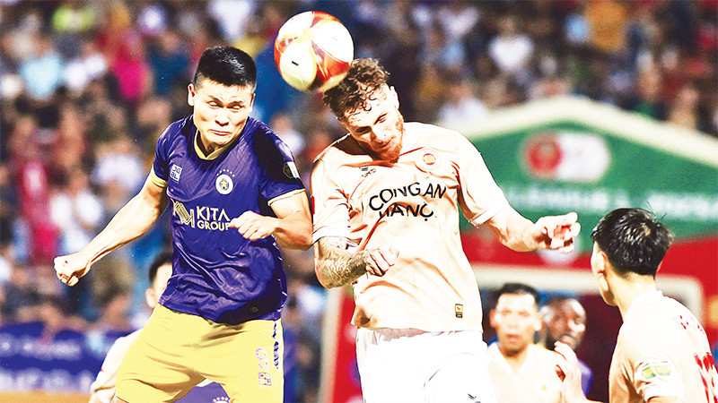 Pha tranh bóng giữa cầu thủ đội Công an Hà Nội (bên phải) với cầu thủ đội Hà Nội FC. (Ảnh TRẦN HẢI) 