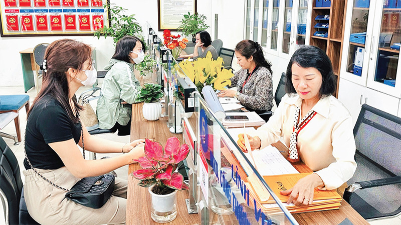 Người dân thực hiện giải quyết thủ tục hành chính tại Bộ phận một cửa quận Ðống Ða. (Ảnh Nguyên Bảo) 