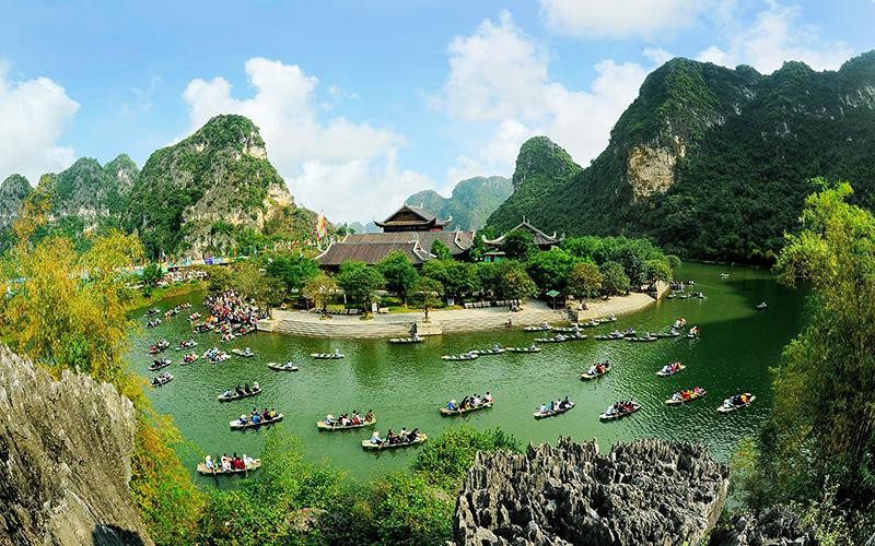 Du khách tham quan Di sản Văn hóa và Thiên nhiên thế giới Tràng An. (Ảnh NINH MẠNH THẮNG) 