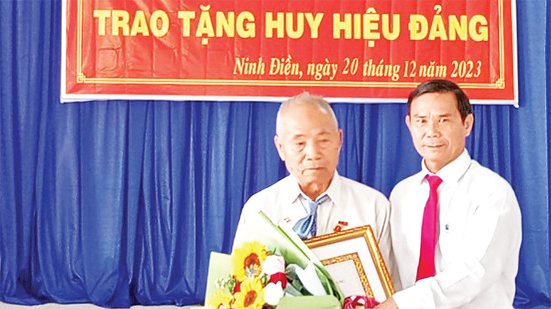 Ðồng chí Thân Văn Nhân, Phó Bí thư Thường trực Huyện ủy Châu Thành (Tây Ninh) trao Huy hiệu 55 năm tuổi đảng tặng đảng viên Lâm Văn Búp. 