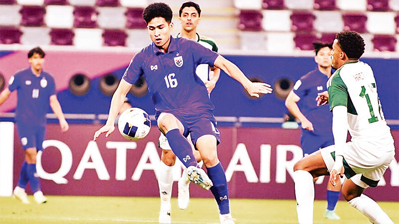 Pha tranh bóng trong trận U23 Thái Lan (áo xanh) thua U23 Saudi Arabia 0-5. 