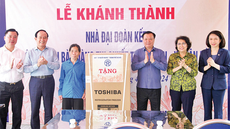 Bí thư Thành ủy Ðinh Tiến Dũng cùng các đồng chí lãnh đạo trao quà mừng nhà mới tặng gia đình bà Hoàng Thị Quyết. (Ảnh Thành Nguyễn) 