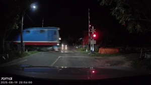 Gác chắn tàu tự động mở khi tàu hỏa lao đến. (Ảnh: Cắt từ clip)
