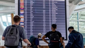 Hành khách xem thông tin trên bảng điện tử tại sân bay quốc tế I Gusti Ngurah Rai ở Bali, Indonesia. (Ảnh: XINHUA)