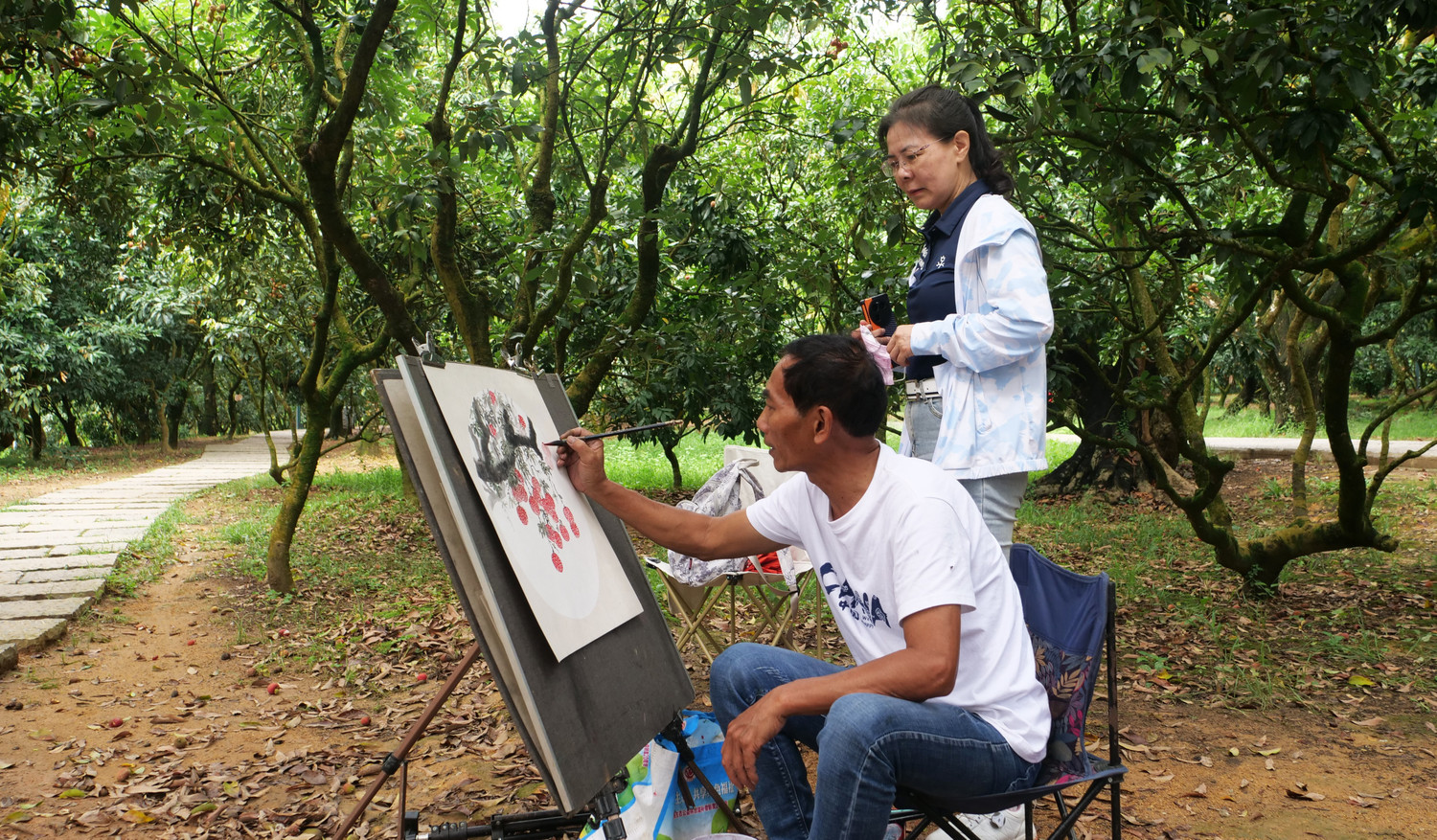 Du khách đi dạo trong dưới bóng cây vải thiều nghìn năm tuổi.