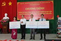 Đồng chí Nguyễn Văn Nên, Ủy viên Bộ Chính trị, Bí thư Thành ủy Thành phố Hồ Chí Minh trao bảng tượng trưng tặng sách và thiết bị học tập cho 3 trường tại Côn Đảo (Ảnh Ban tổ chức).