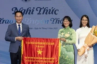 Phó Chủ tịch Ủy ban nhân dân Thành phố Hồ Chí Minh Trần Thị Diệu Thúy trao Cờ Truyền thống của Ủy ban nhân dân Thành phố cho đại diện Bảo tàng Chứng tích Chiến tranh. (Ảnh: Quốc Thanh)