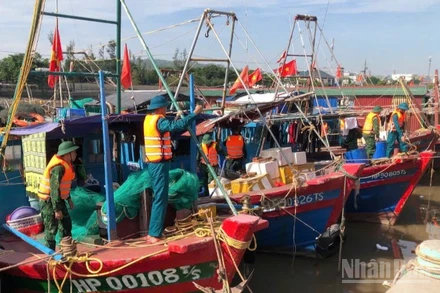 Cán bộ, chiến sĩ Đồn Biên phòng Đồ Sơn hỗ trợ ngư dân chằng buộc phương tiện tại khu vực neo đậu.