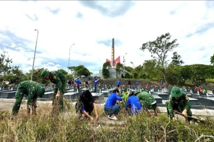 Cán bộ, chiến sĩ của Đồn Biên phòng An Hải và đoàn viên, thanh niên địa phương tham gia dọn dẹp, chỉnh trang khuôn viên nghĩa trang liệt sĩ.