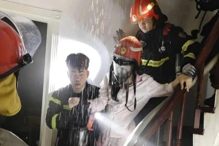 Giải cứu 1 người bị mắc kẹt trong đám cháy. (Ảnh: Công an Hà Nội)