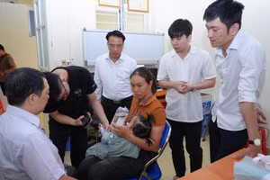 Đồng chí Phạm Giang Nam, Giám đốc Sở Y tế Điện Biên thăm, động viên trẻ em trước khi được bác sĩ phẫu thuật. Ảnh: BÍCH DUYÊN