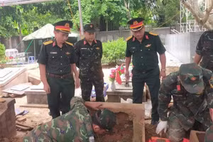 Các lực lượng tham gia lấy mẫu hài cốt liệt sĩ tại nghĩa trang liệt sĩ Tuần Giáo. (Ảnh: ĐỨC HẠNH)