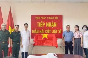 Thành viên Ban Chỉ đạo tìm kiếm, xác định danh tính liệt sĩ tỉnh Điện Biên bàn giao mẫu hài cốt liệt sĩ cho Viện Pháp y Quân đội. (Ảnh: ĐỨC HẠNH)