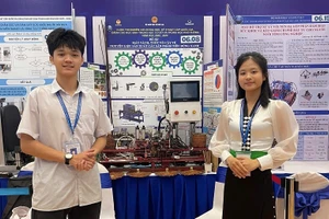 Em Nguyễn Tiến Mạnh và Dương Thị Duyên bên "Máy tách, tuốt vỏ cây tế - nguyên liệu sản xuất sản phẩm tiêu dùng xanh" được trao giải Tư tại Cuộc thi. 