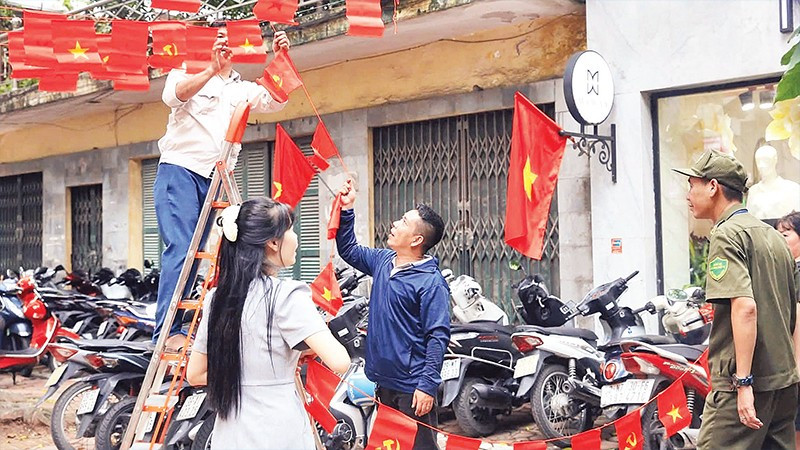 Người dân Hà Nội trang trí cờ hoa mừng Quốc khánh. (Ảnh NGUYỄN VŨ)