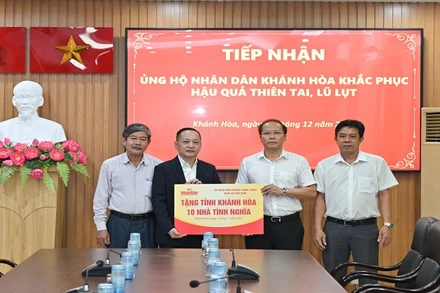 Đồng chí Nguyễn Khắc Hà (thứ hai từ phải sang) tiếp nhận hỗ trợ từ Báo Nhân Dân. (Ảnh: VĨNH THÀNH) 